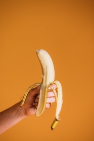 手拿黄色剥皮香蕉图片