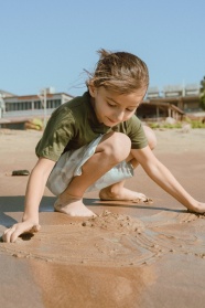 小女孩在沙滩上玩沙子图片