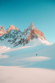 在白色雪山雪地行走的图片