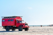 沙滩上的红色大卡车图片