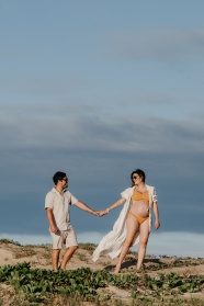 孕妇与伴侣在海滩上散步图片