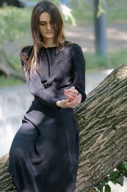 坐在树干上的黑色连衣裙美女图片