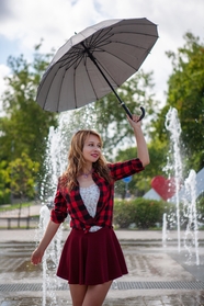站在喷泉广场上撑伞美女图片