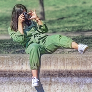 手持相机拍照的绿色工装连体衣美女图片