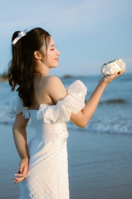 海边白色连衣裙美女侧颜写真摄影图片