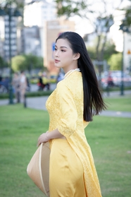亚洲草地黄色奥黛美女写真摄影图片