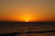 日暮黄昏海平面上徐徐落下的夕阳图片