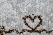 摆在水泥地上的爱心咖啡豆背景图片