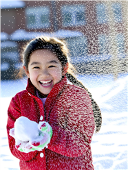 冬季雪地搓雪球的小女孩图片
