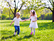 春天草地上手牵手的孩童图片