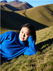 蓝色羊毛衫美女侧躺在草地上图片