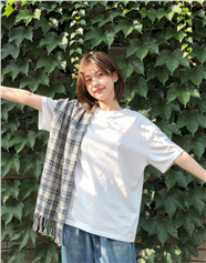 站在绿色藤蔓前的白色T恤美女图片